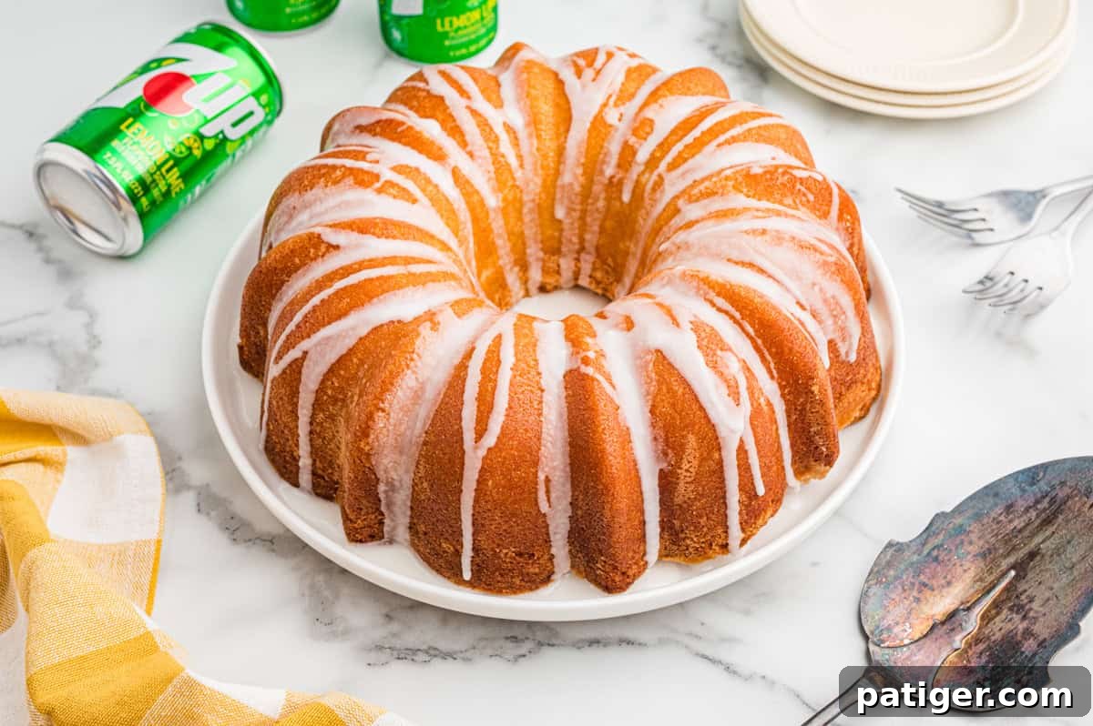 7 Up pound cake with glaze drizzled over the top and cans of 7 Up soda in the background.