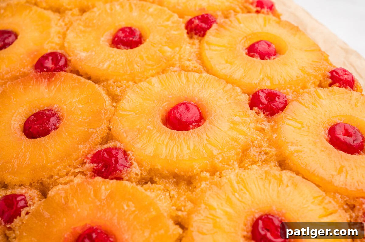 Overhead view of finished pineapple upside down cake with rows of cherry-centered pineapple rings in a brown sugar glaze.