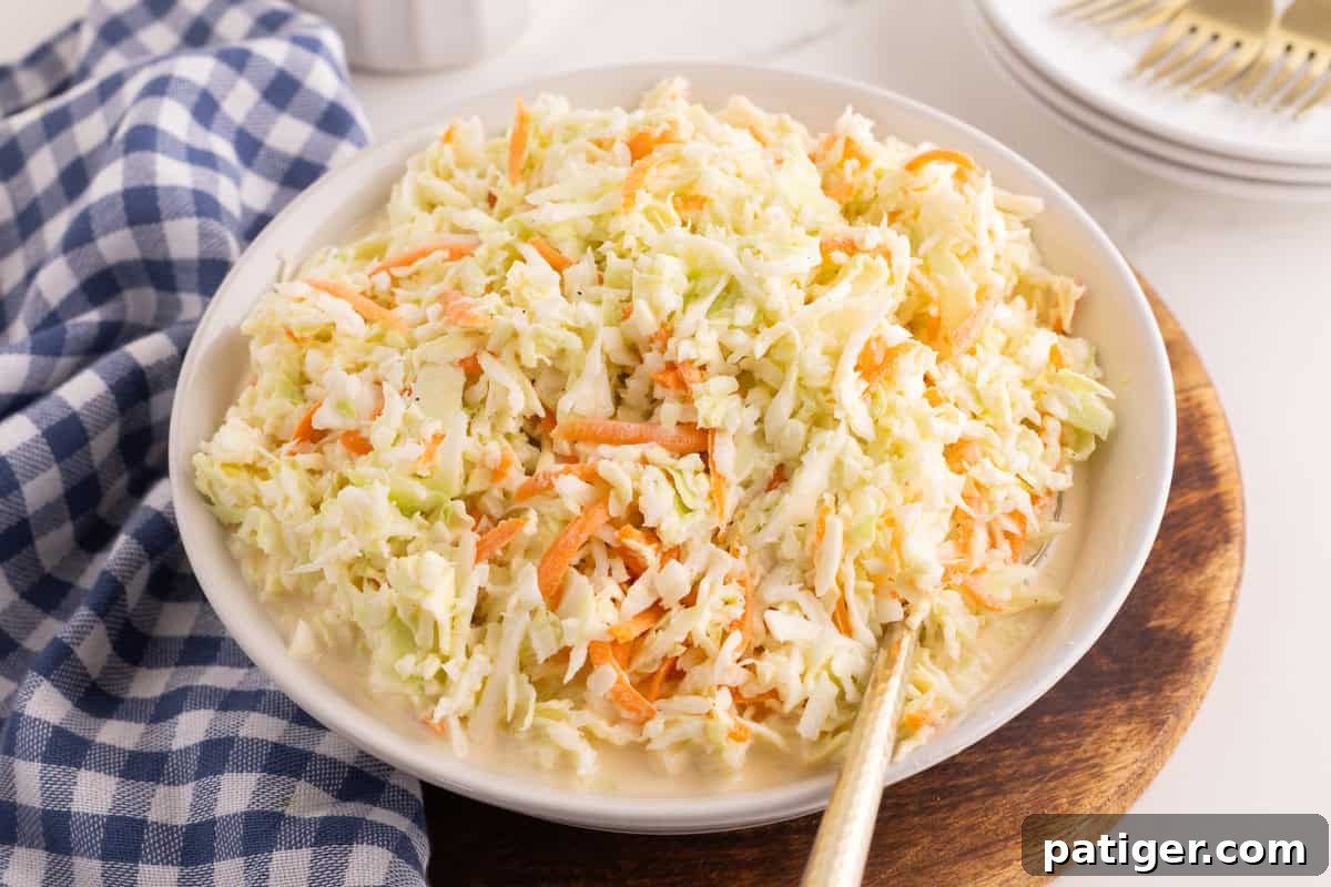 Bowl of homemade coleslaw with a spoon resting in it.