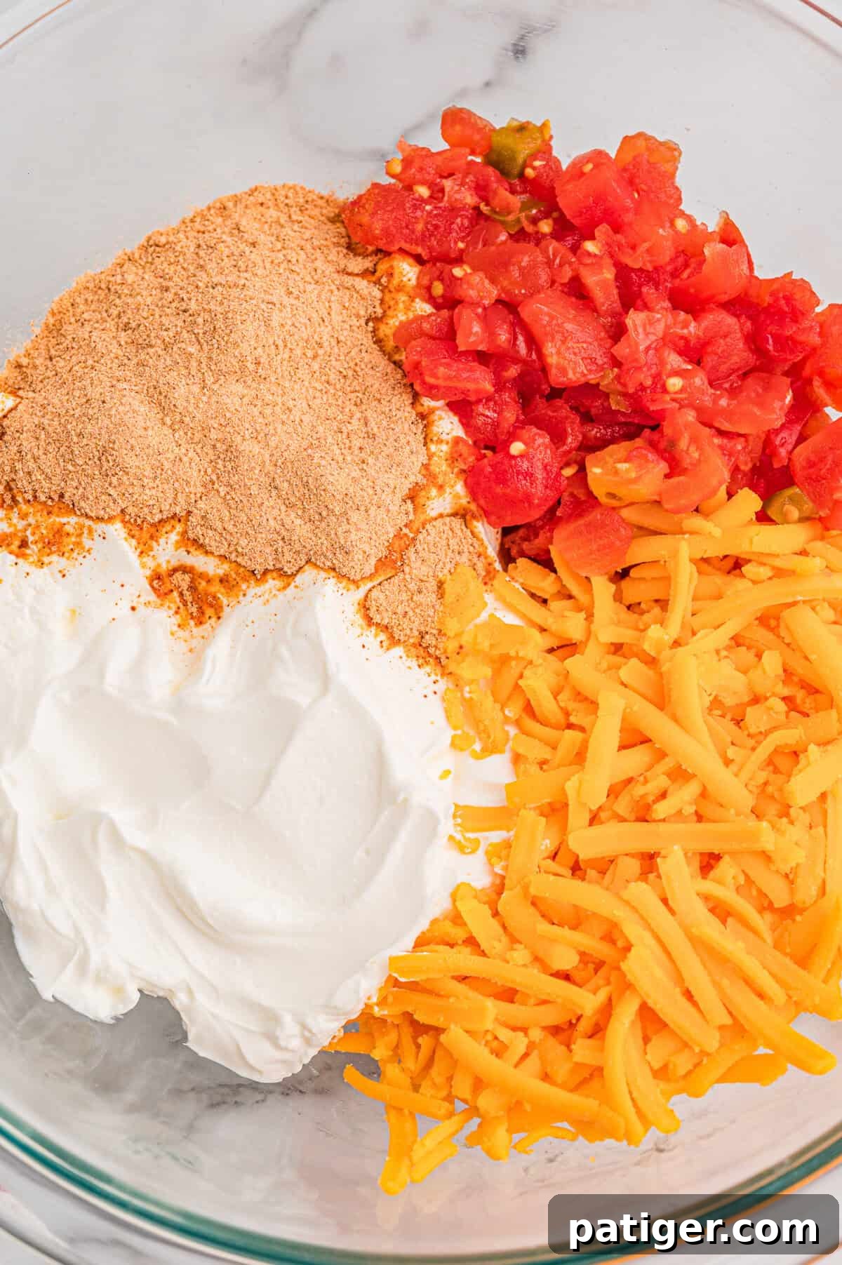 How to Swim Safely from Your Boat 4 Sour cream, taco seasoning, diced tomatoes with green chilies, and shredded cheddar in a glass mixing bowl.