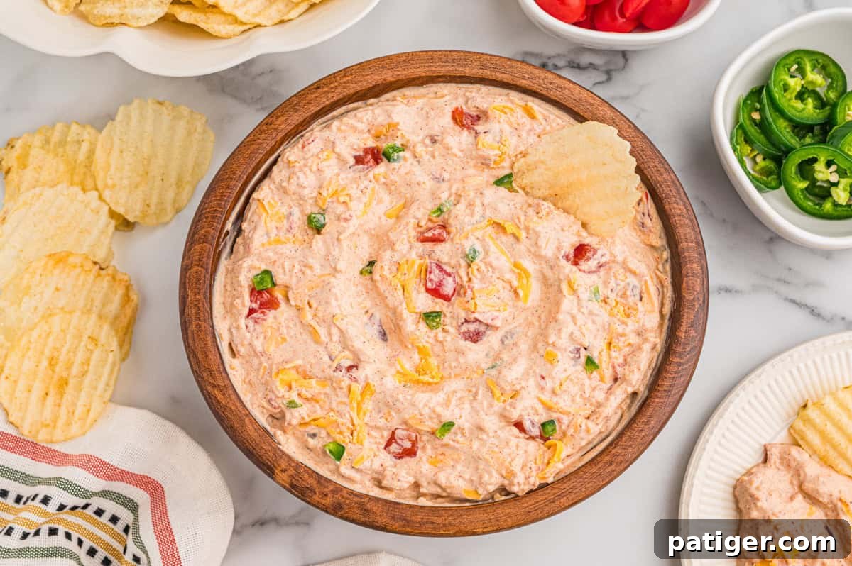 How to Swim Safely from Your Boat 5 Boat dip in a wooden bowl surrounded by ruffled potato chips, sliced jalapenos, and diced tomatoes.