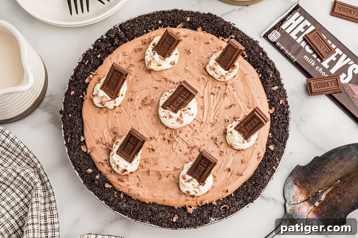 Homemade Hershey's Chocolate Pie Recipe 10 Overhead view of a whole chocolate pie in an Oreo crust topped with whipped cream and Hershey's bars.