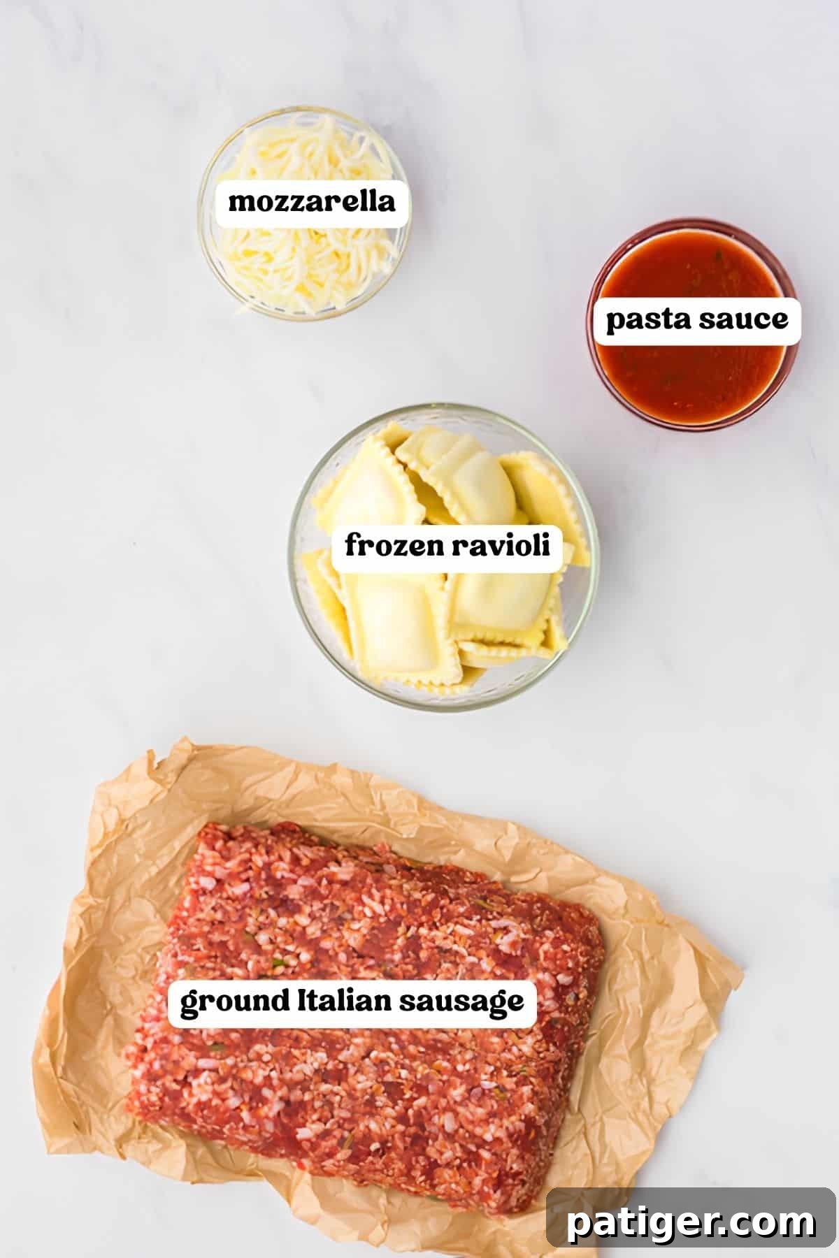 Shredded mozzarella, jarred pasta sauce, frozen ravioli, and ground Italian sausage arranged in bowls on a marble counter.