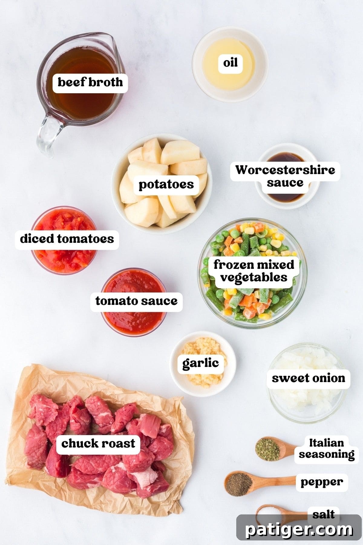 Labeled ingredients on white: beef broth, oil, potatoes, Worcestershire sauce, diced tomatoes, tomato sauce, frozen mixed vegetables, garlic, sweet onion, chuck roast, and seasonings.