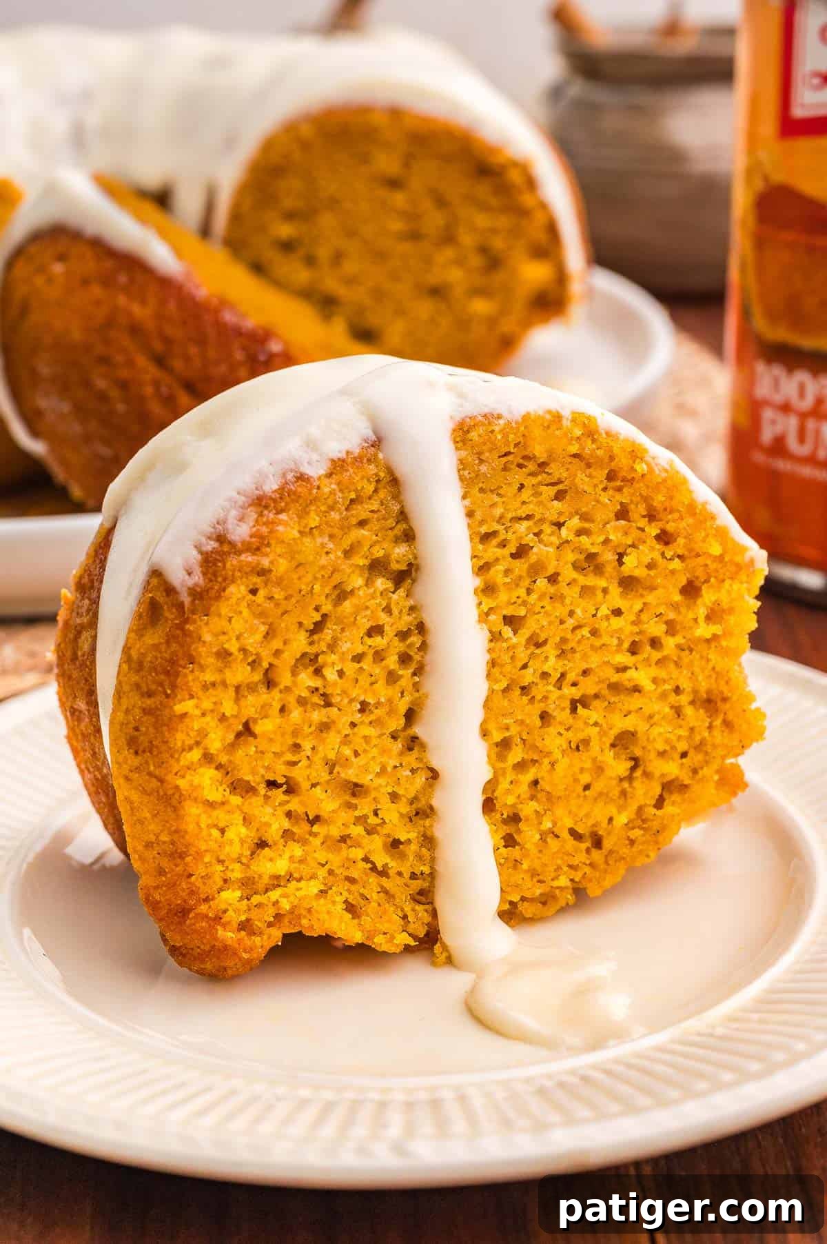 Moist Pumpkin Bundt Cake Made with Cake Mix 10 Sliced pumpkin bundt cake on a white plate with glaze, cut slices fanned out to the left.