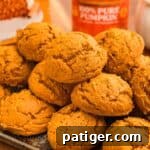 Cake Mix Pumpkin Cookies: Soft Spiced Fall Treats 11 Stacked pumpkin cookies on a dark tray with a 100% pure pumpkin can behind.